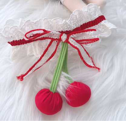 Lace headband with red bow and cherry decorations on a white background