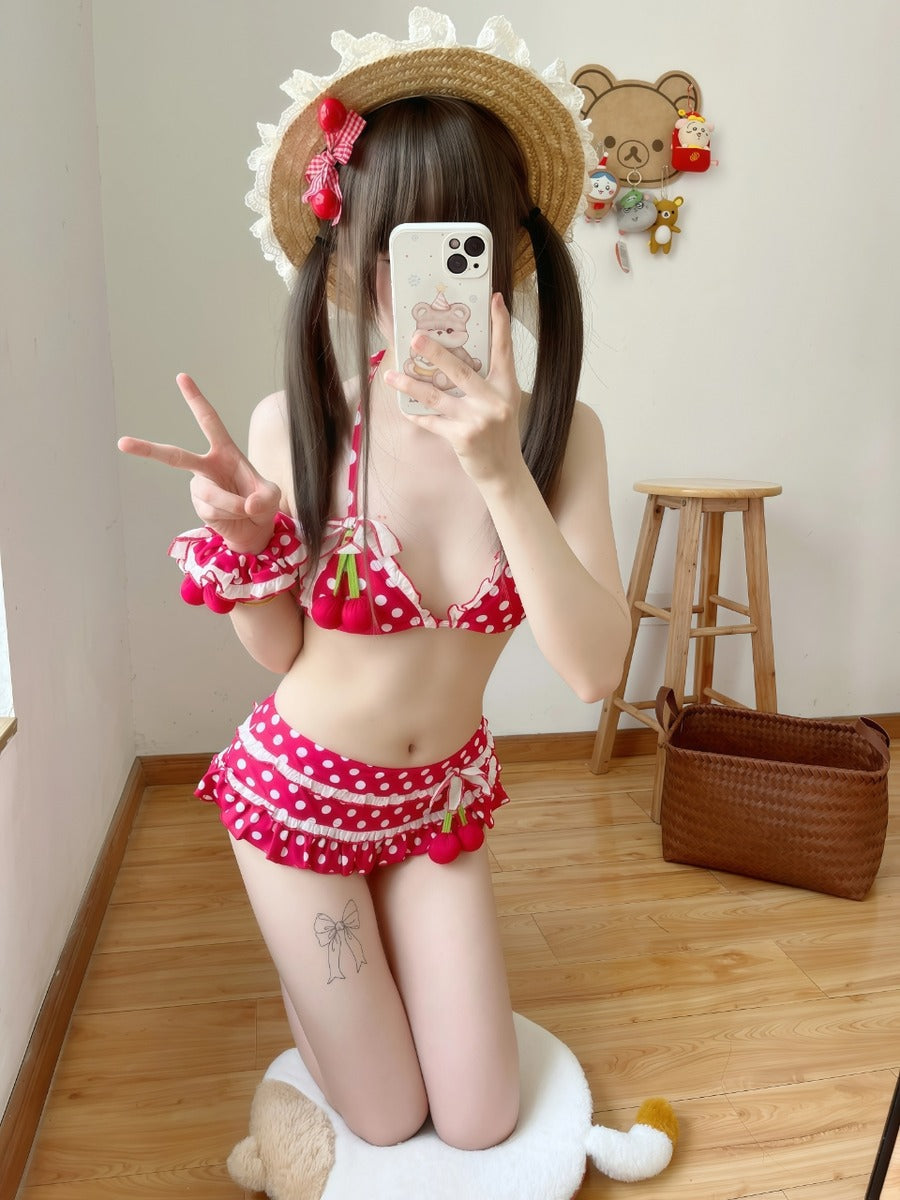 Person wearing a red polka dot bikini taking a mirror selfie in a room.