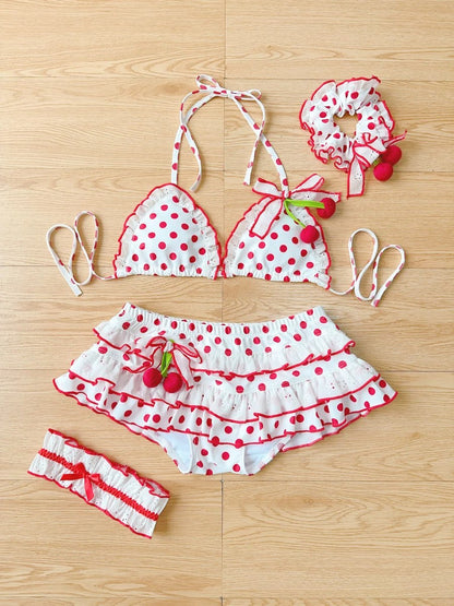 Polka dot bikini set with cherry details on a wooden surface