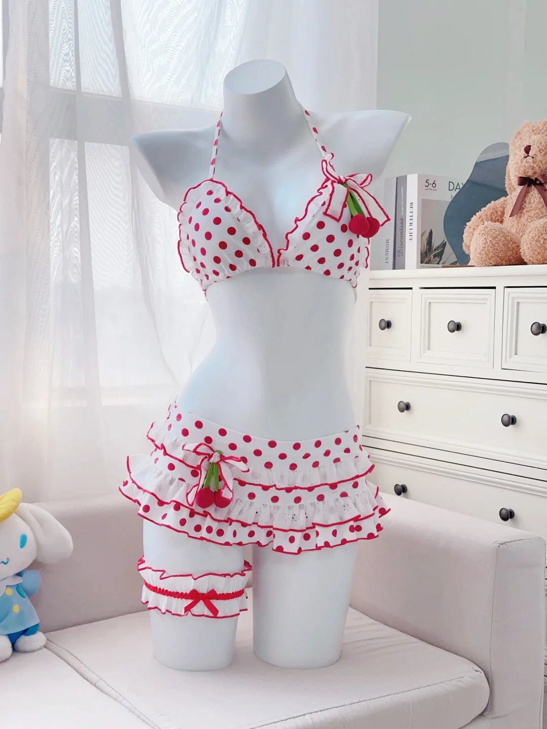 Mannequin wearing a red and white polka dot bikini with ruffles in a room setting.