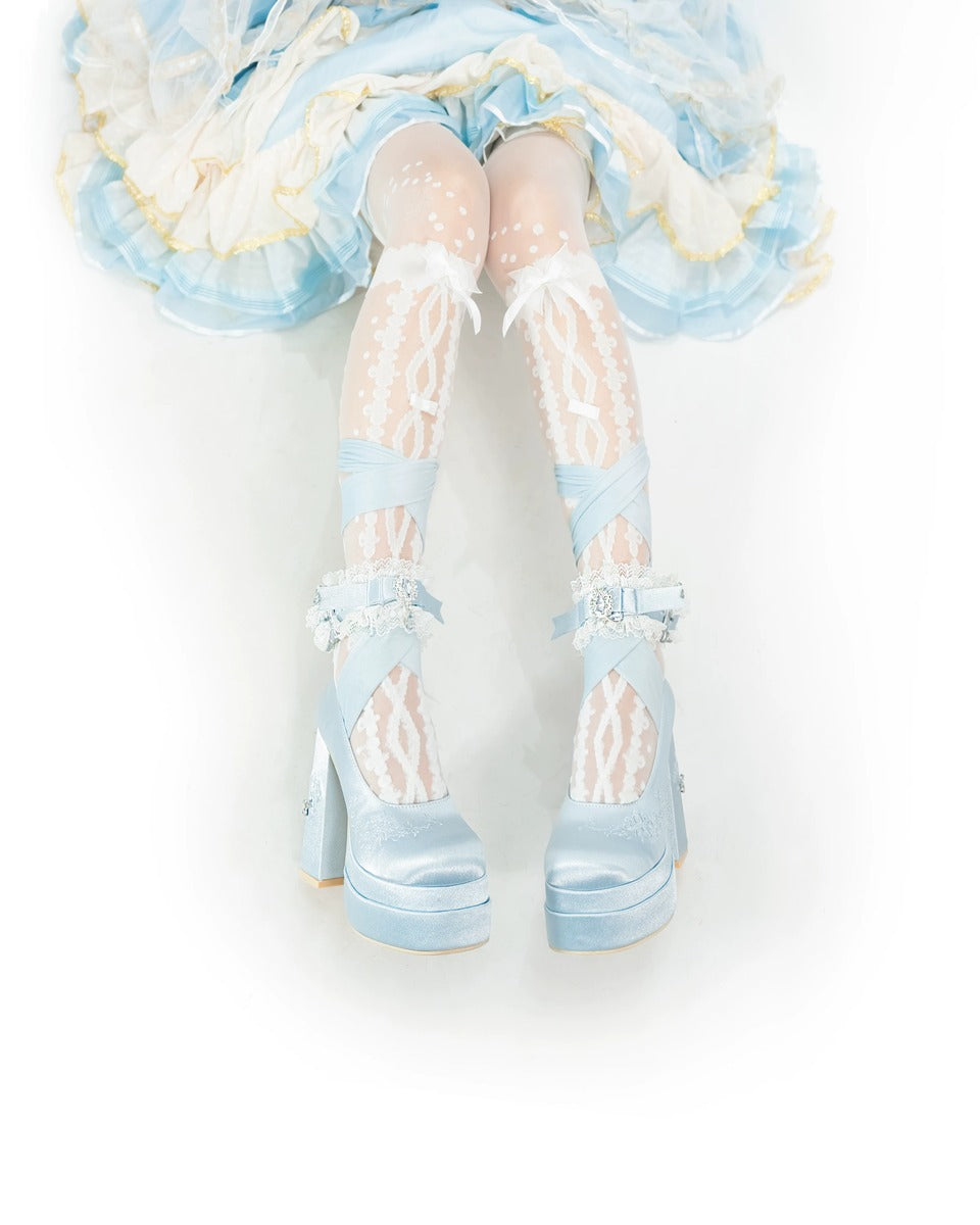 Light blue high-heeled shoes worn with a pastel outfit on a white background