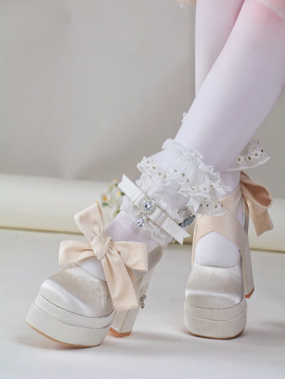 White platform shoes with bows and lace details on a light background