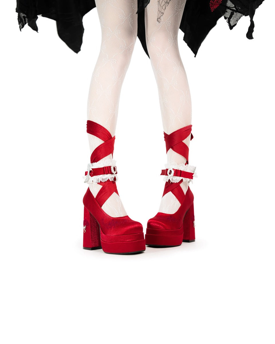 Red platform shoes with white soles on a white background
