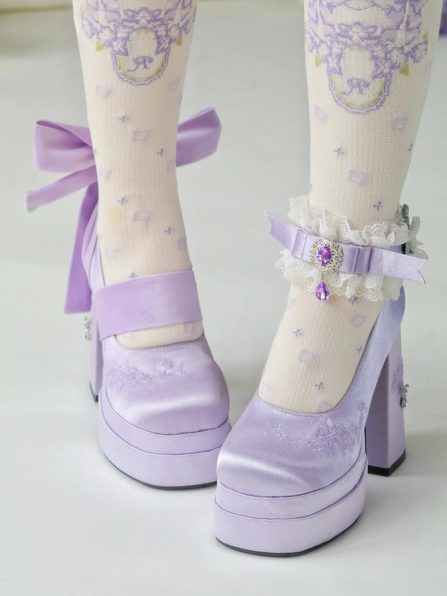 Lavender high-heeled shoes with decorative ribbons and ankle straps on a light background