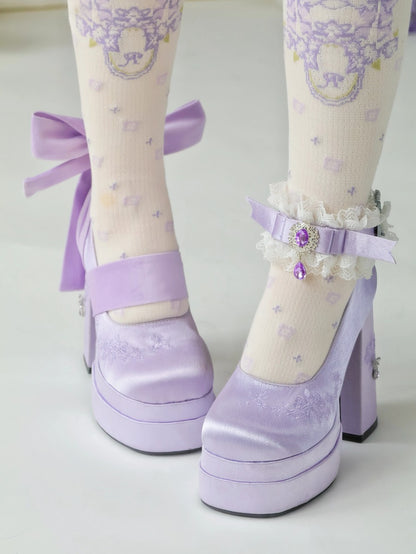 Lavender high-heeled shoes with decorative ribbons and ankle straps on a light background