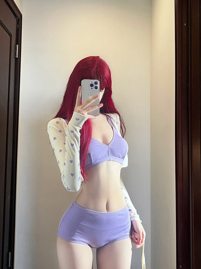 Person wearing a light purple bikini swimsuit with a sheer long-sleeve top, taking a mirror selfie.