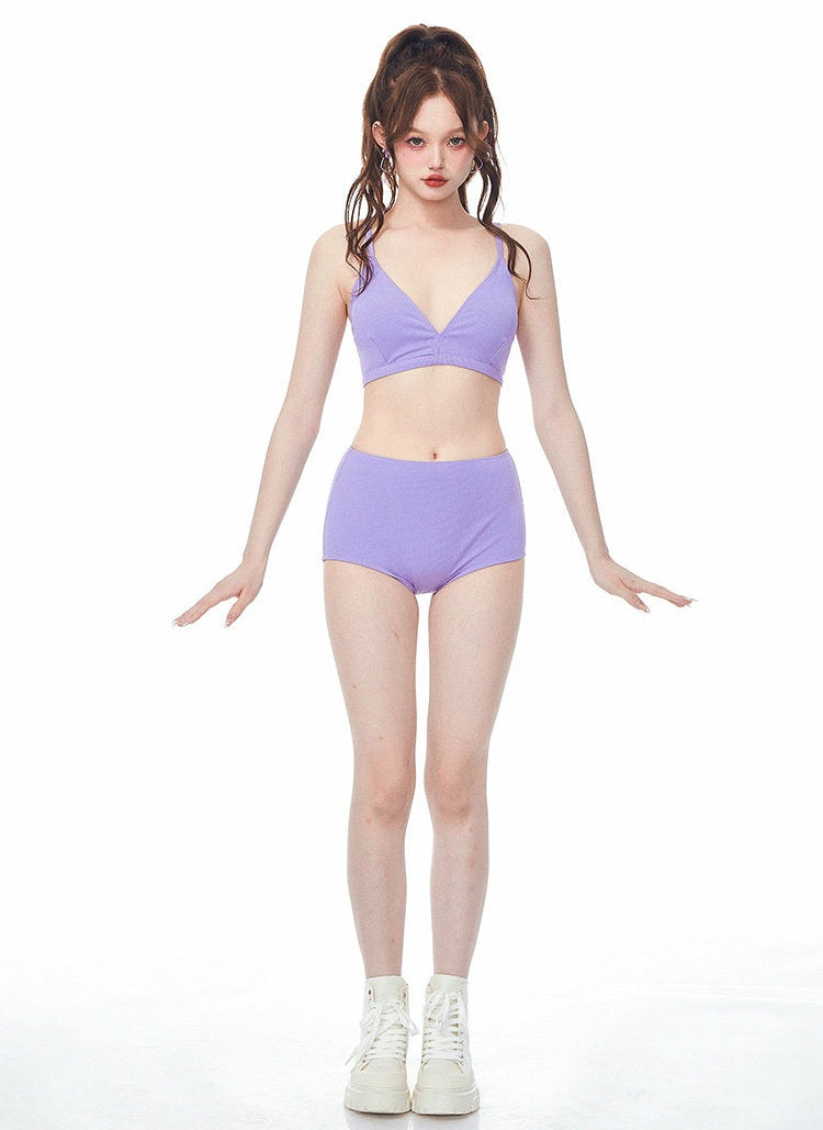 Person wearing a purple bikini set on a white background