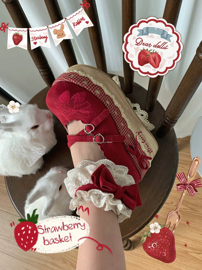 Red sandal with white lace and bow on a wooden chair, surrounded by strawberry-themed decorations.