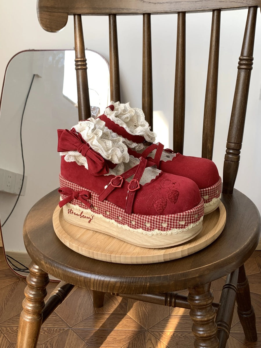 Cottagecore Red children's shoes with white ruffles on a wooden chair.