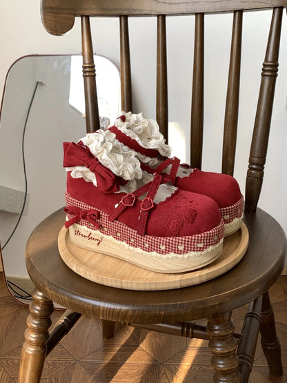 Cottagecore Red children's shoes with white ruffles on a wooden chair.