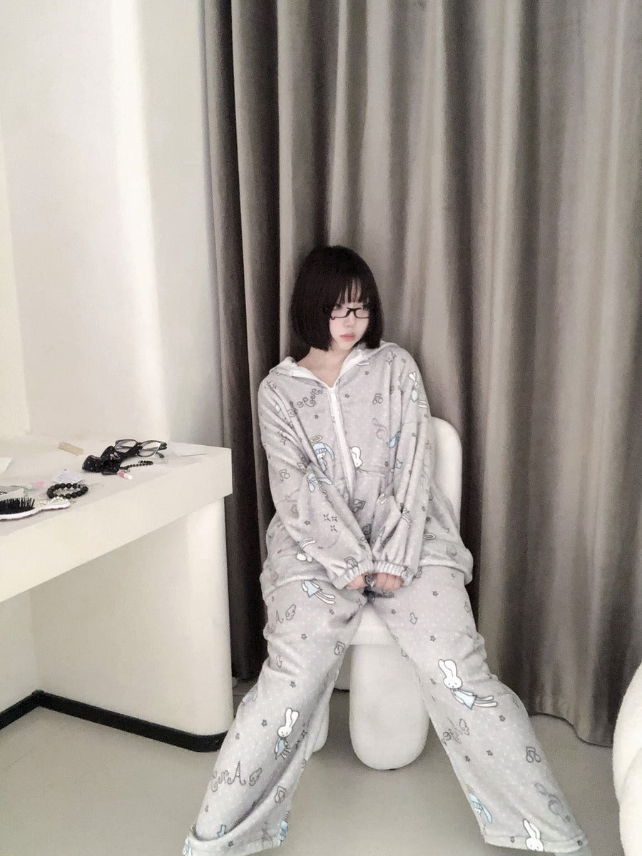 Person wearing a light gray onesie with cartoon characters sitting on a white chair.