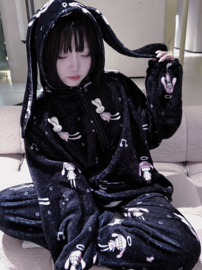 Person wearing a black plushie-style pajamas with cartoon character designs.