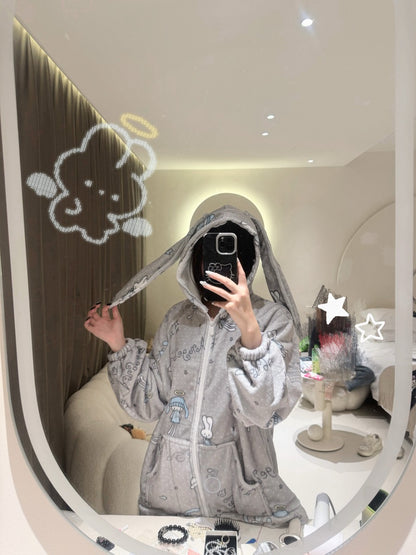Person wearing a gray hoodie with cartoon character ears, taking a mirror selfie.