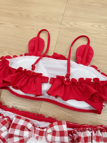 Red and white bikini set on a wooden floor