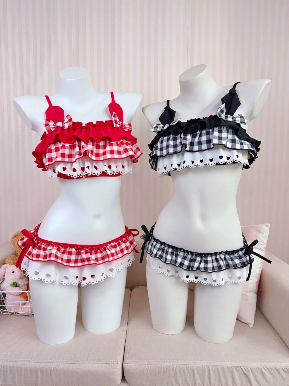 Two mannequins wearing red and black checkered outfits on a light pink background.