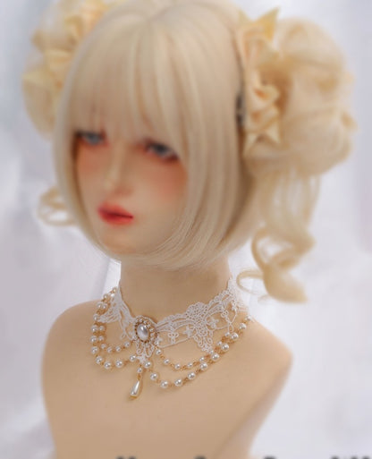 Mannequin head with blonde hair styled in pigtails and a decorative necklace on a white background