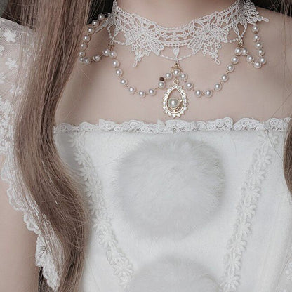 Close-up of a person wearing a delicate lace top and pearl necklace.