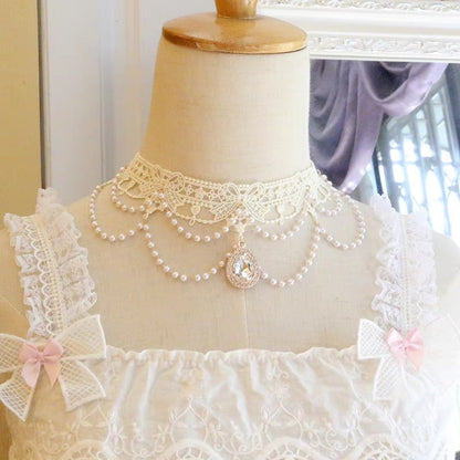 Mannequin wearing a white lace dress with a pearl necklace