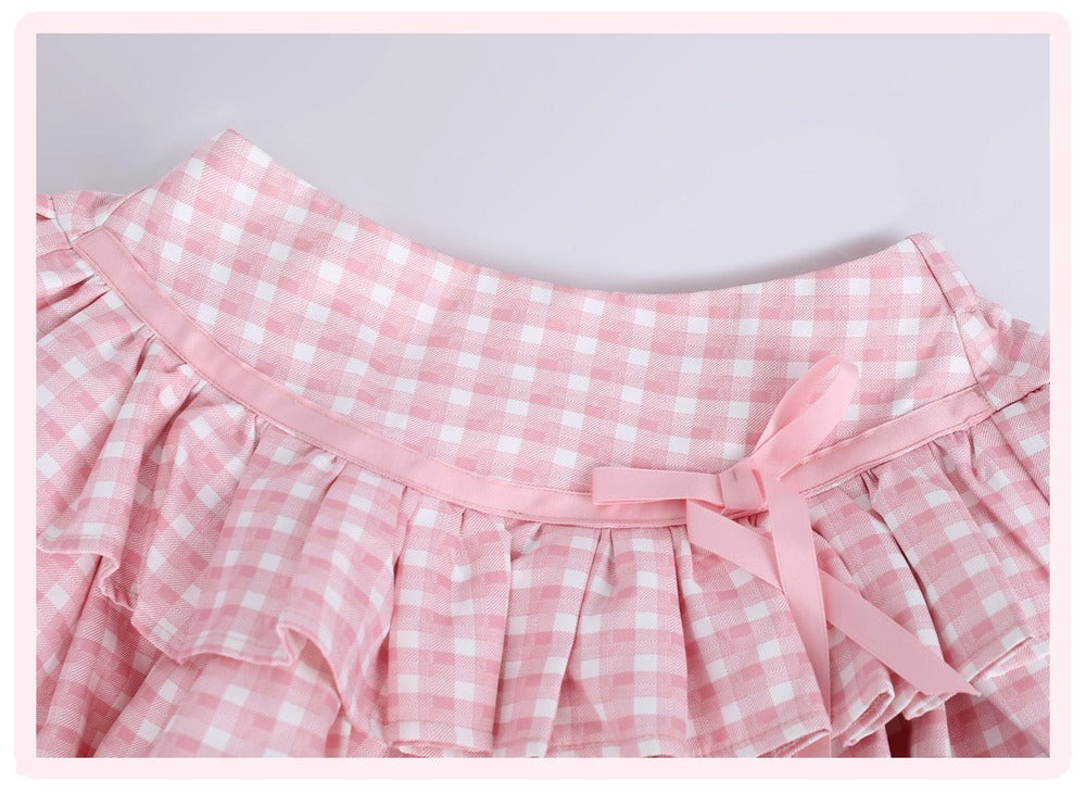 Pink and white gingham check skirt with a ruffled waistband and a matching pink ribbon bow at the center, shown against a light gray background.