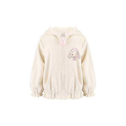 A cream-colored zip-up hoodie for girls, featuring a cute pink cartoon bunny character on the left chest, a pink pom-pom zipper pull, and ruffled trim along the hood, cuffs, and hem.