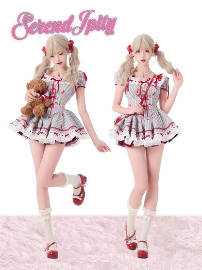 Two identical dolls in a white dress with red accents, holding a teddy bear, on a pink textured background.