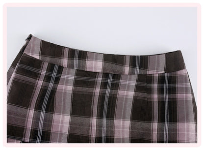 A close-up of a plaid skirt in dark brown, black, and dusty pink, showing the waistband and fabric texture against a light gray background.