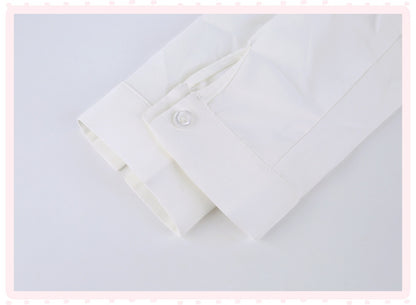 A close-up of a white long-sleeve dress shirt cuff with a single button closure, shown on a light gray background with a decorative pink border.