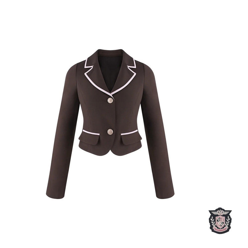 A dark brown cropped blazer with white piping trim on the notched lapels and pocket edges, featuring a single front button and two front flap pockets, shown against a plain white background.