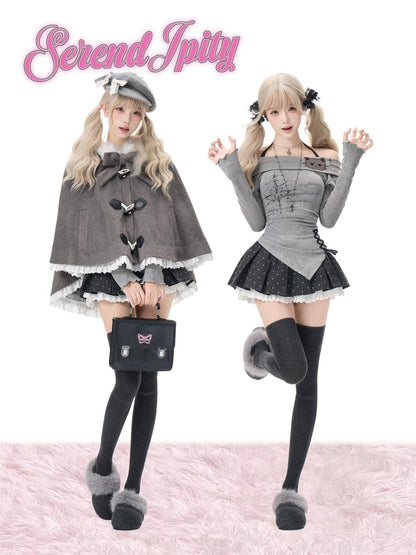 Two models showcase gothic Lolita fashion outfits from on a white background with a pink faux fur floor. The left model wears a gray cape with black buttons, a black and white frilly skirt, and holds a black handbag.