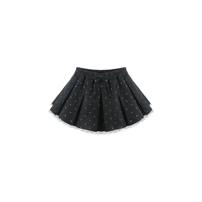 A black pleated mini skirt with a small white polka dot pattern and a matching bow at the waistband, shown against a plain white background.