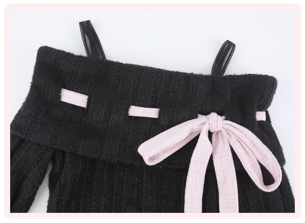 Close-up of a black ribbed knit garment with thin shoulder straps, small light pink rectangular accents, and a large light pink bow at the front, shown on a white background with a pink border.