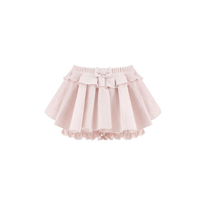 A light pink tiered ruffle skirt with a matching fabric bow at the center waist, displayed against a solid white background.