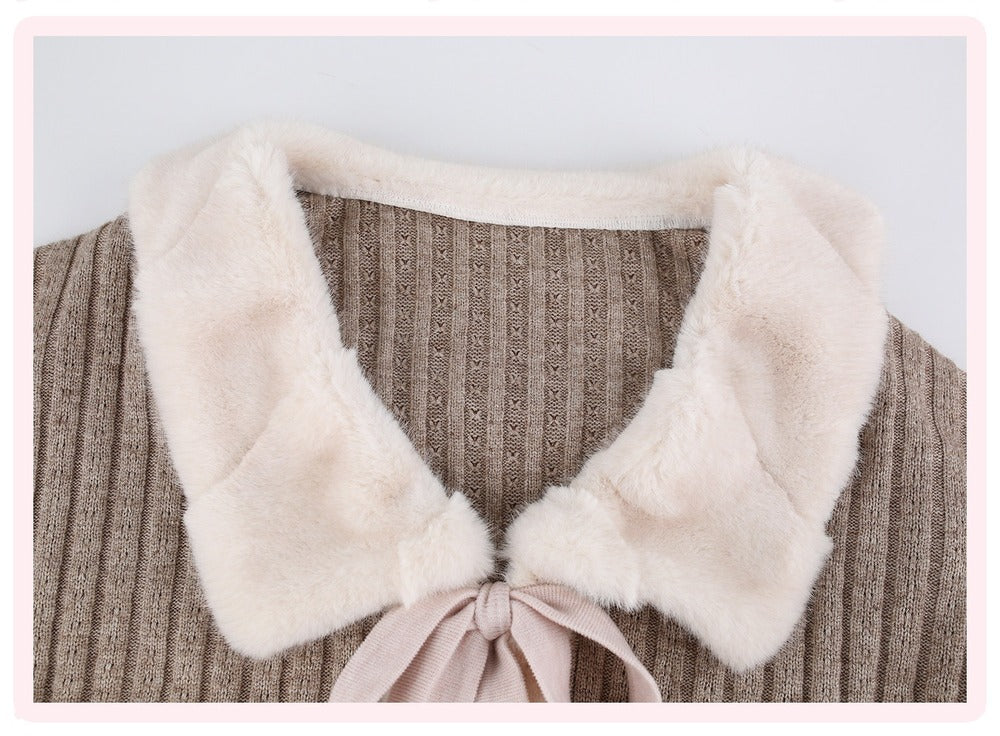 Close-up of a ribbed knit top with a large cream faux-fur collar and a pale pink ribbon tie at the neckline.