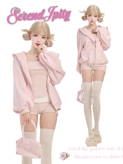 Person wearing a pink outfit with matching accessories, standing against a plain background.