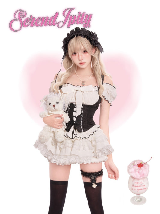 Person in a black and white outfit holding a teddy bear
