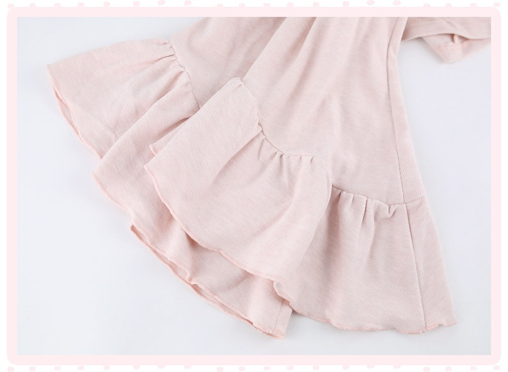 A close-up of a light pink tiered ruffle dress or skirt made from lightweight fabric, shown against a white background with a decorative pink border.