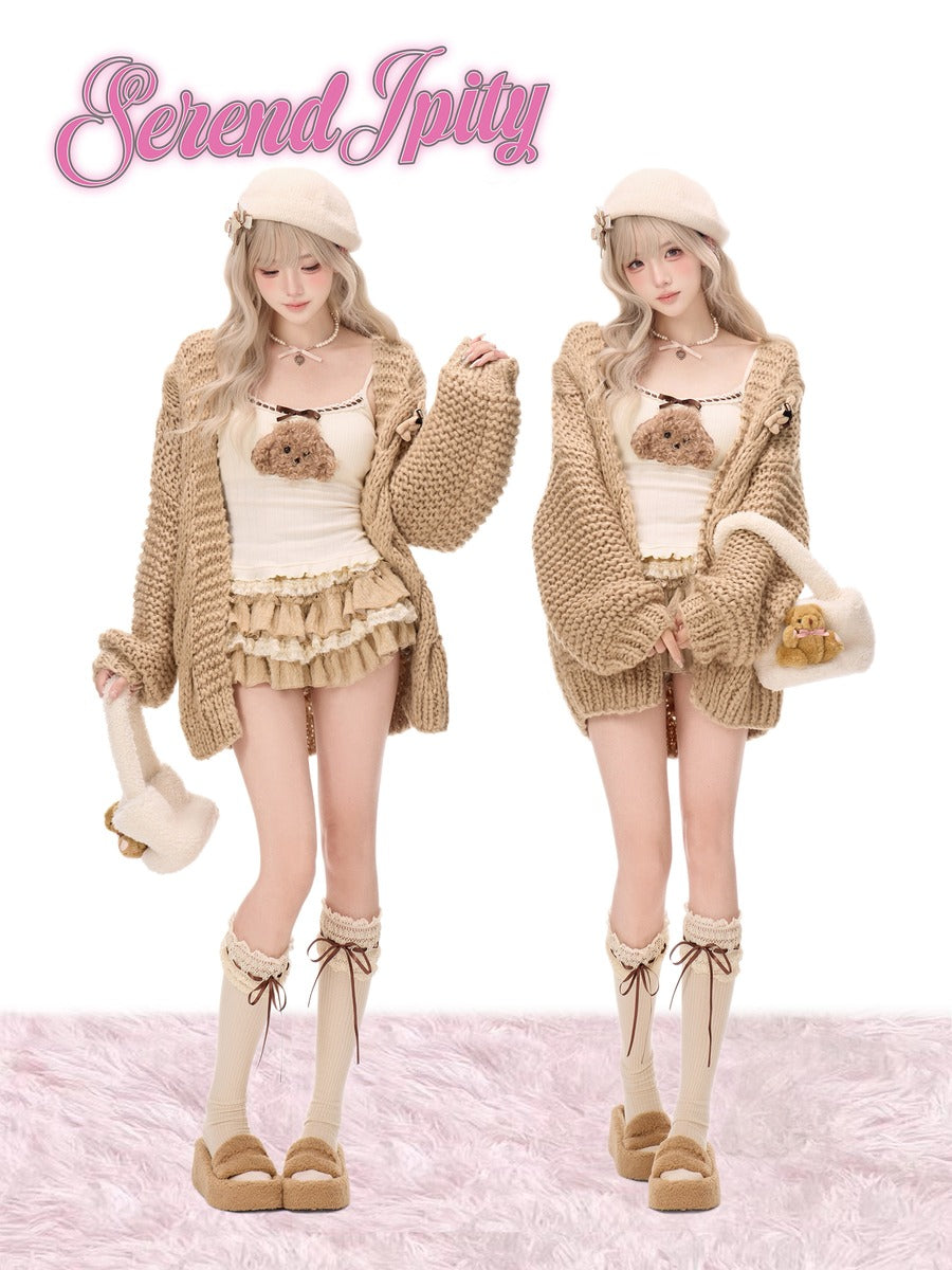 Two models wearing a cozy beige and cream outfit with a chunky knit cardigan, ruffled mini dress, cream beret, knee-high socks, and platform loafers, posed against a white background with a pink fluffy floor and 'Serendipity' at the top.