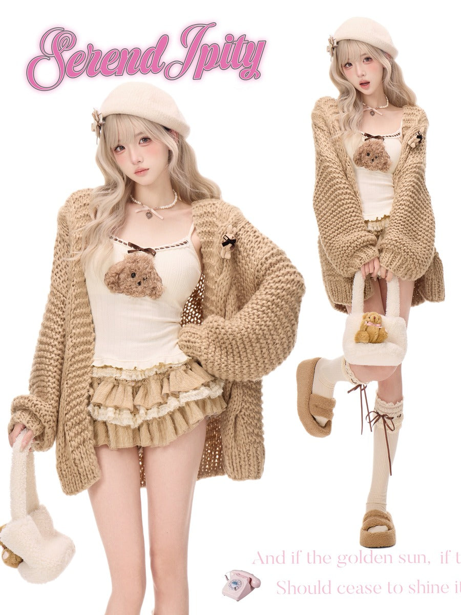 A fashion collage on a white background showing a model in two poses wearing a beige chunky knit cardigan over a cream ruffled top and skirt, with a matching beret, lace-up socks, a small teddy bear accessory, and a fuzzy handbag. Pink decorative text reads 'Serendipity' and additional quote text appears at the bottom.