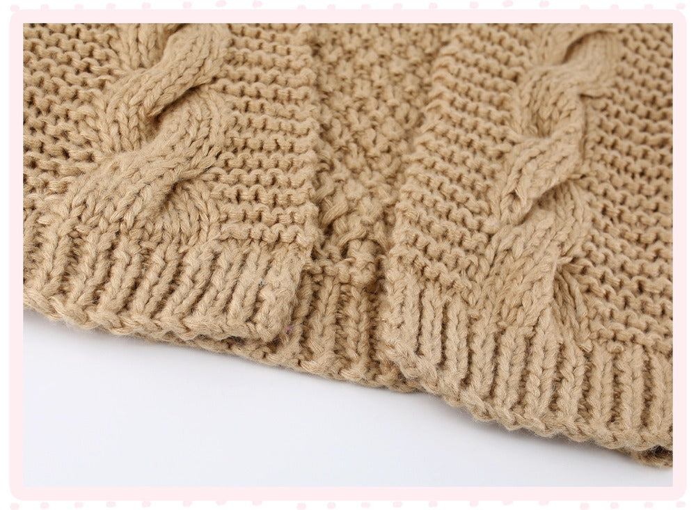 Close-up of a beige cable-knit fabric with a ribbed cuff, shown folded on a white background with a light pink decorative border.