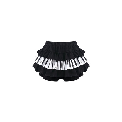 A black ruffled skirt with alternating horizontal bands of white and black piano keys, shown against a plain white background.