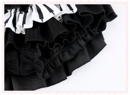 A close-up of a black ruffled skirt with a contrasting white and black striped ruffled trim, set against a white background with a light pink border.