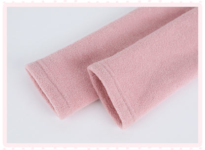 A close-up of a soft pink fabric, folded diagonally on a light gray background with a decorative pink border.