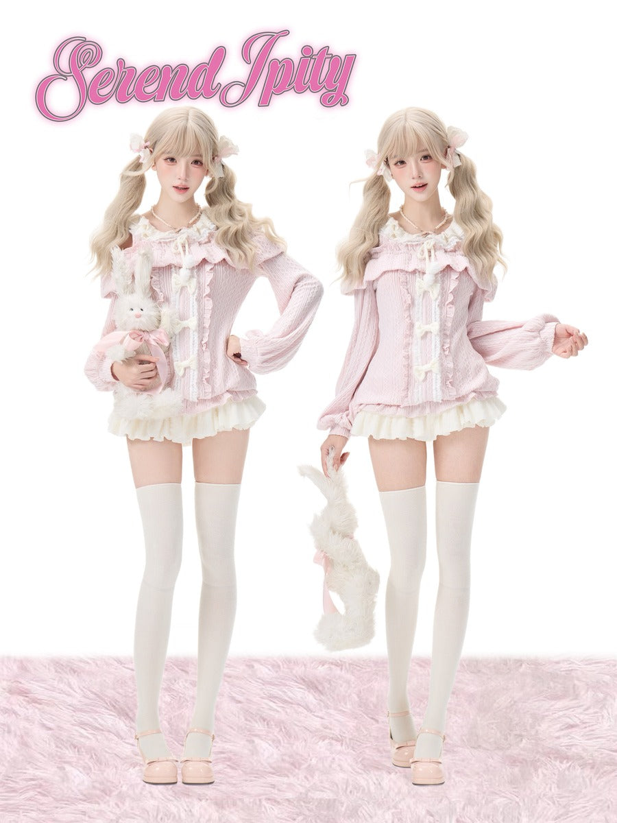 Two models wearing matching pastel pink and white frilly Lolita-style outfits with bunny accessories, standing against a white background with a pink fluffy rug. The name 'Serendipity' is displayed in pink script at the top.