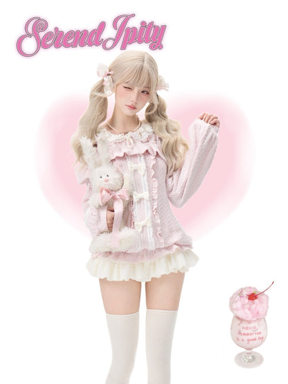 A blonde model wearing a pink and white frilly Lolita-style outfit with a matching plush bunny, set against a white background with a pink heart outline. The 'Serendipity' is displayed in pink script at the top left, and a dessert glass graphic appears in the bottom right corner.