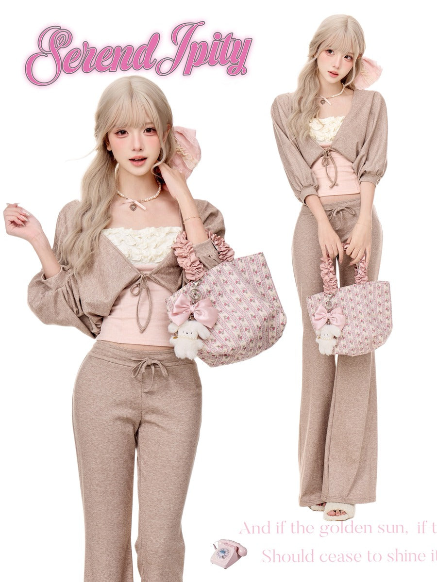 A fashion collage on a white background showing a model in a beige cropped cardigan and matching drawstring sweatpants with a pink floral tote bag, alongside a smaller view of the same outfit. The brand name 'Serendipity' appears in pink script at the top.