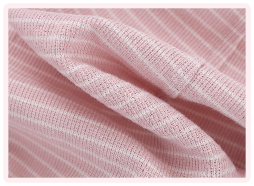 A close-up of soft pink knit fabric with thin white vertical stripes, shown with gentle folds and a light pink border around the edges.