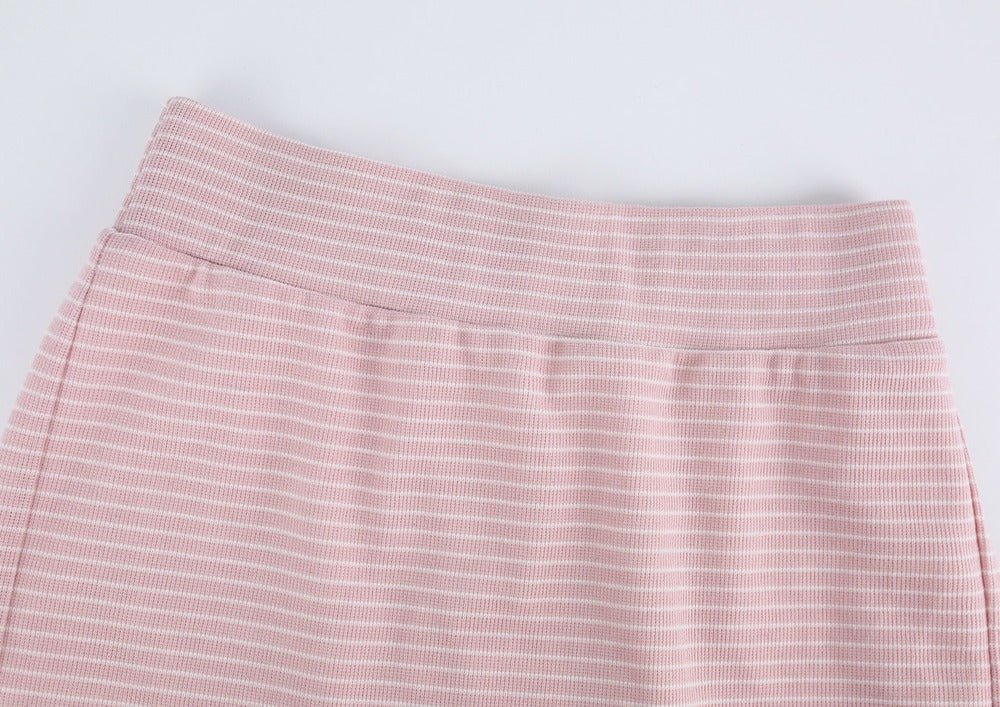 Close-up of a pink and white striped skirt showing the waistband and fabric texture against a light gray background.