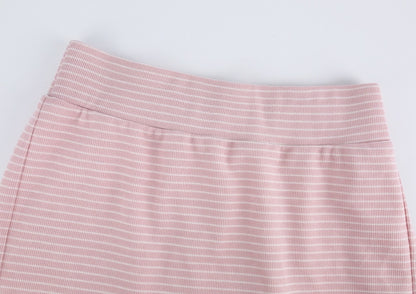 Close-up of a pink and white striped skirt showing the waistband and fabric texture against a light gray background.