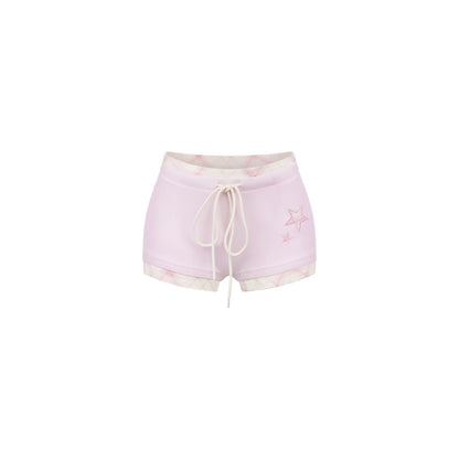 Pink shorts with a white drawstring on a white background
