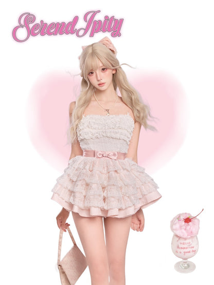 Person wearing a light pink lace dress, holding a dessert.